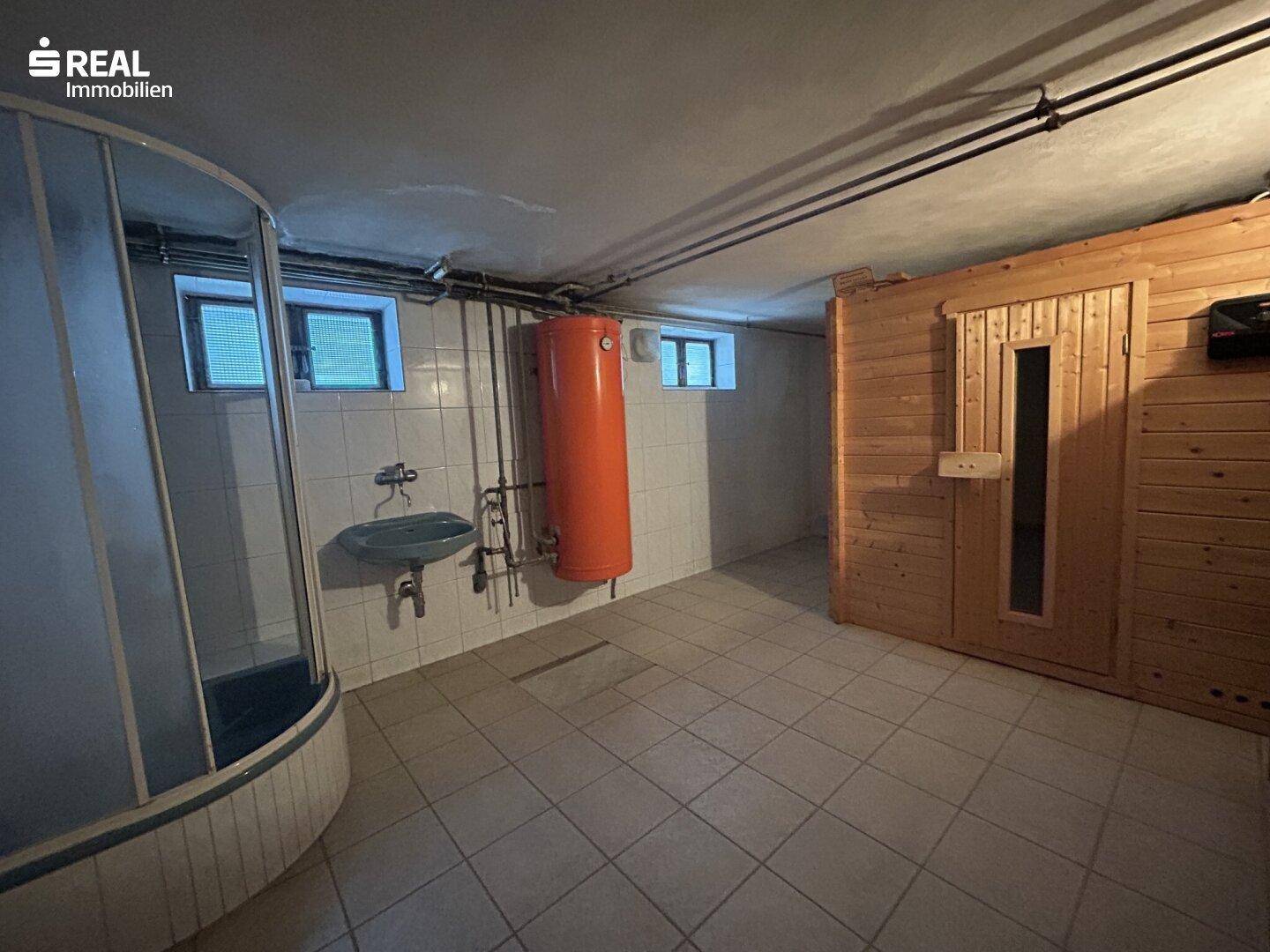 Badezimmer im Untergeschoss mit Dusche, Waschbecken und integrierter Holzsauna.