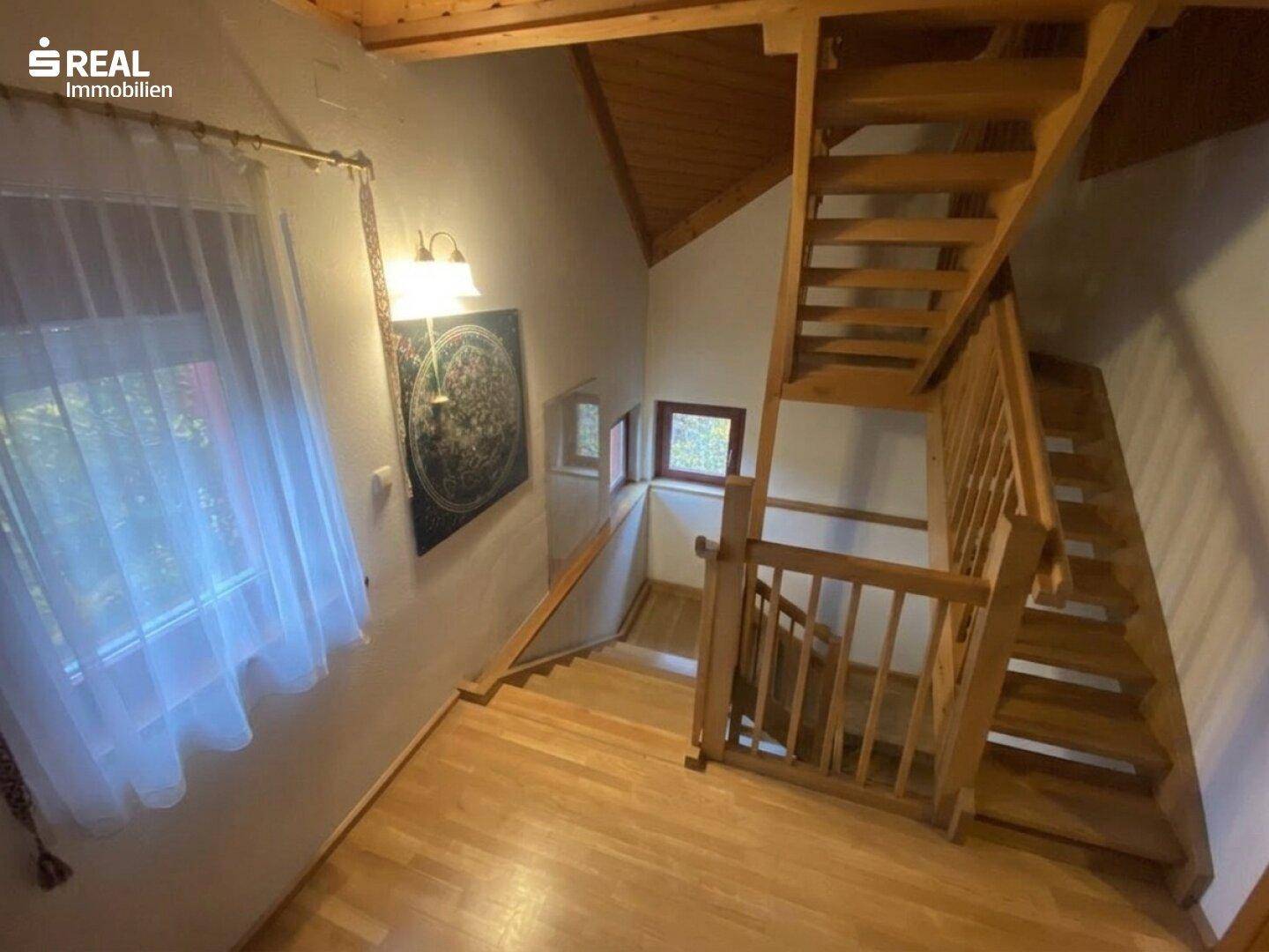 Offener Treppenbereich mit Holztreppe und Holzboden, der die verschiedenen Etagen verbindet.