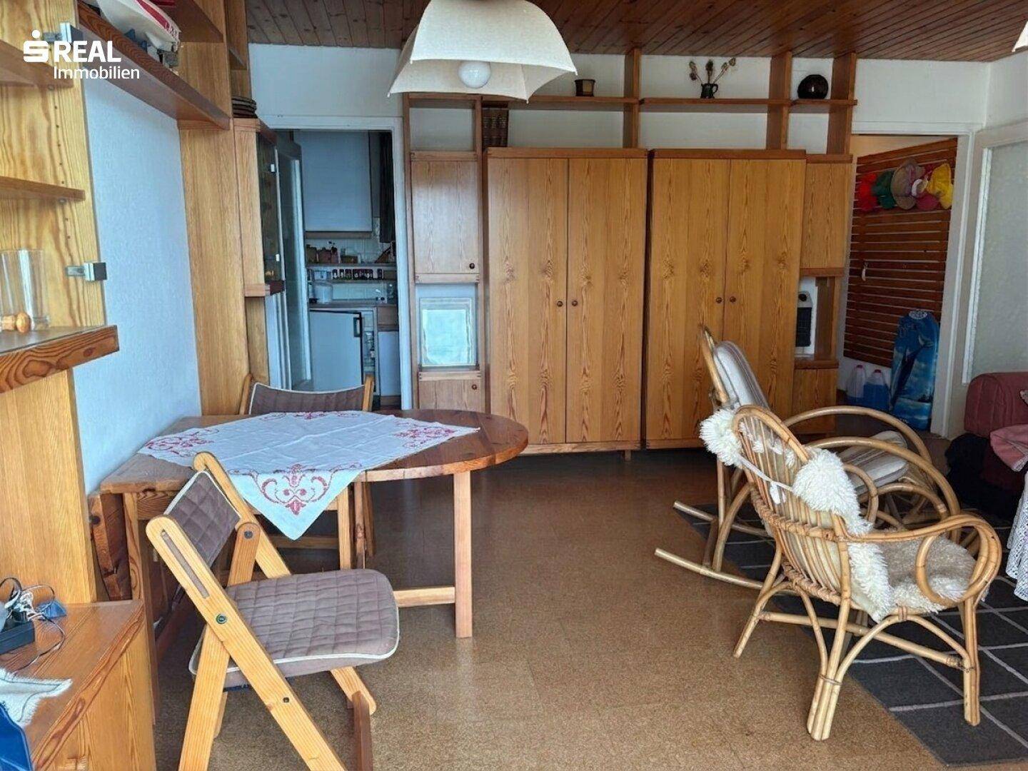 Gemütlicher Wohnbereich mit Holztäfelung an der Decke und traditionellen Holzmöbeln.