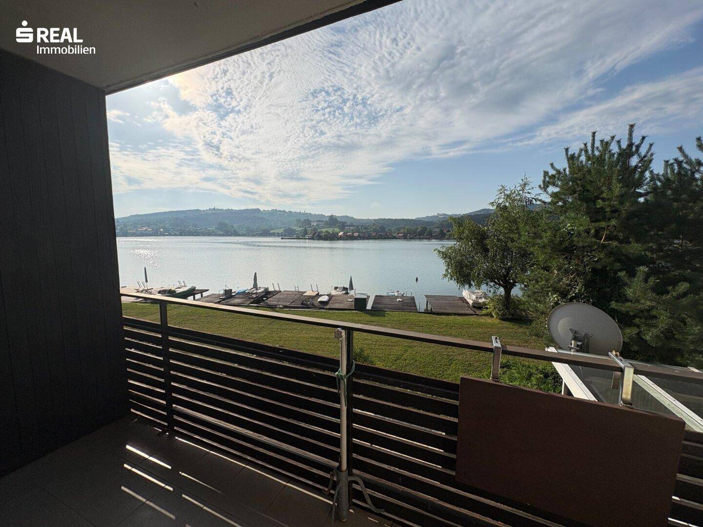 Balkon mit weitem Blick über den See und die umliegende grüne Landschaft.