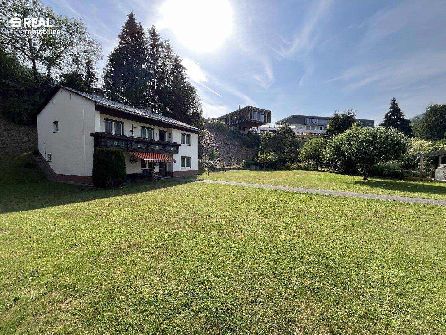 Weitläufiger Gartenbereich vor dem Haus mit Blick auf die umliegende Berglandschaft.
