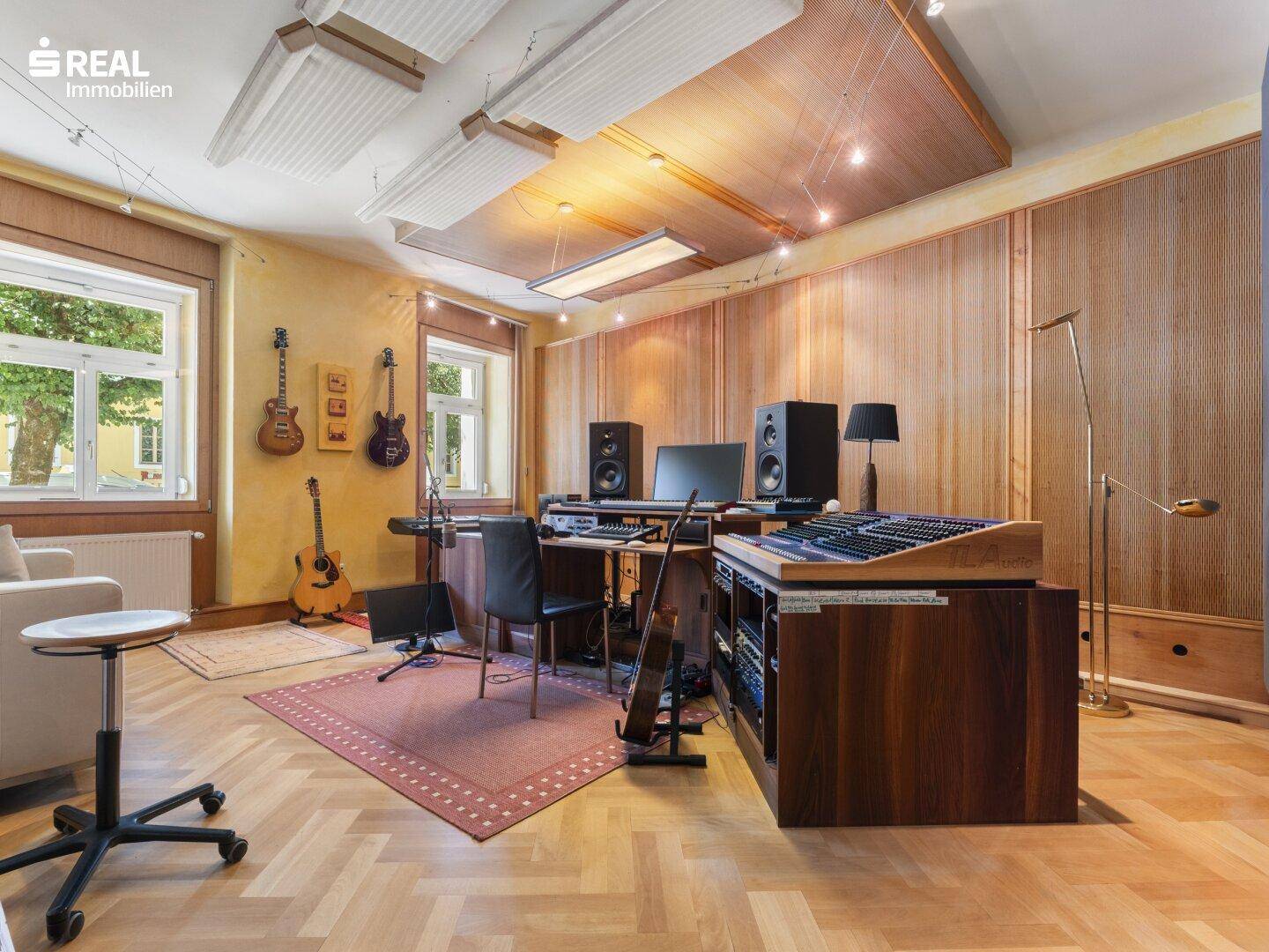 Professionelles Musikstudio mit Holzvertäfelung, Akustikdecken und Musikequipment.