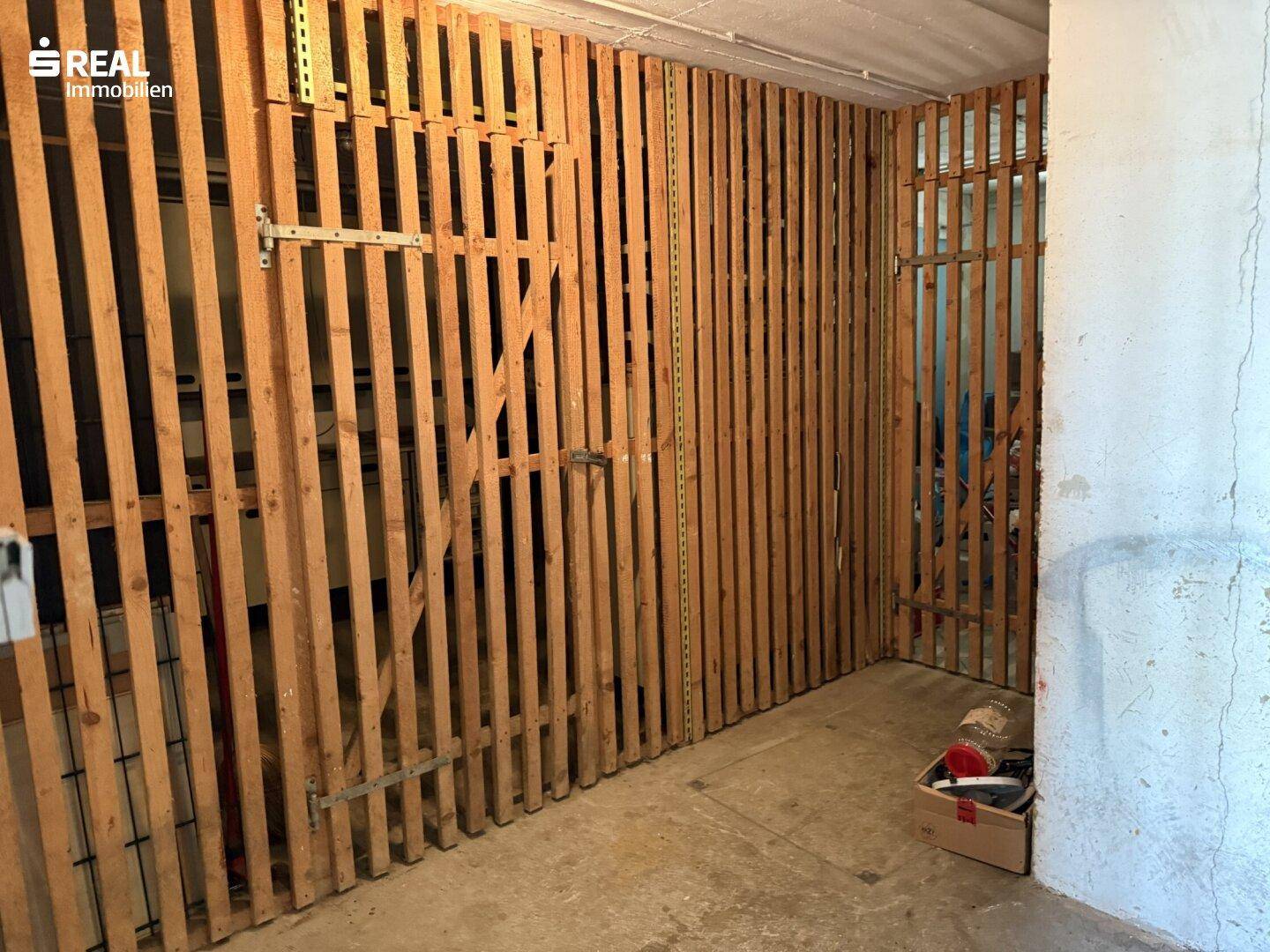 Geräumiger Abstellraum im Keller mit Holzlattenwänden für individuelle Lagerung.