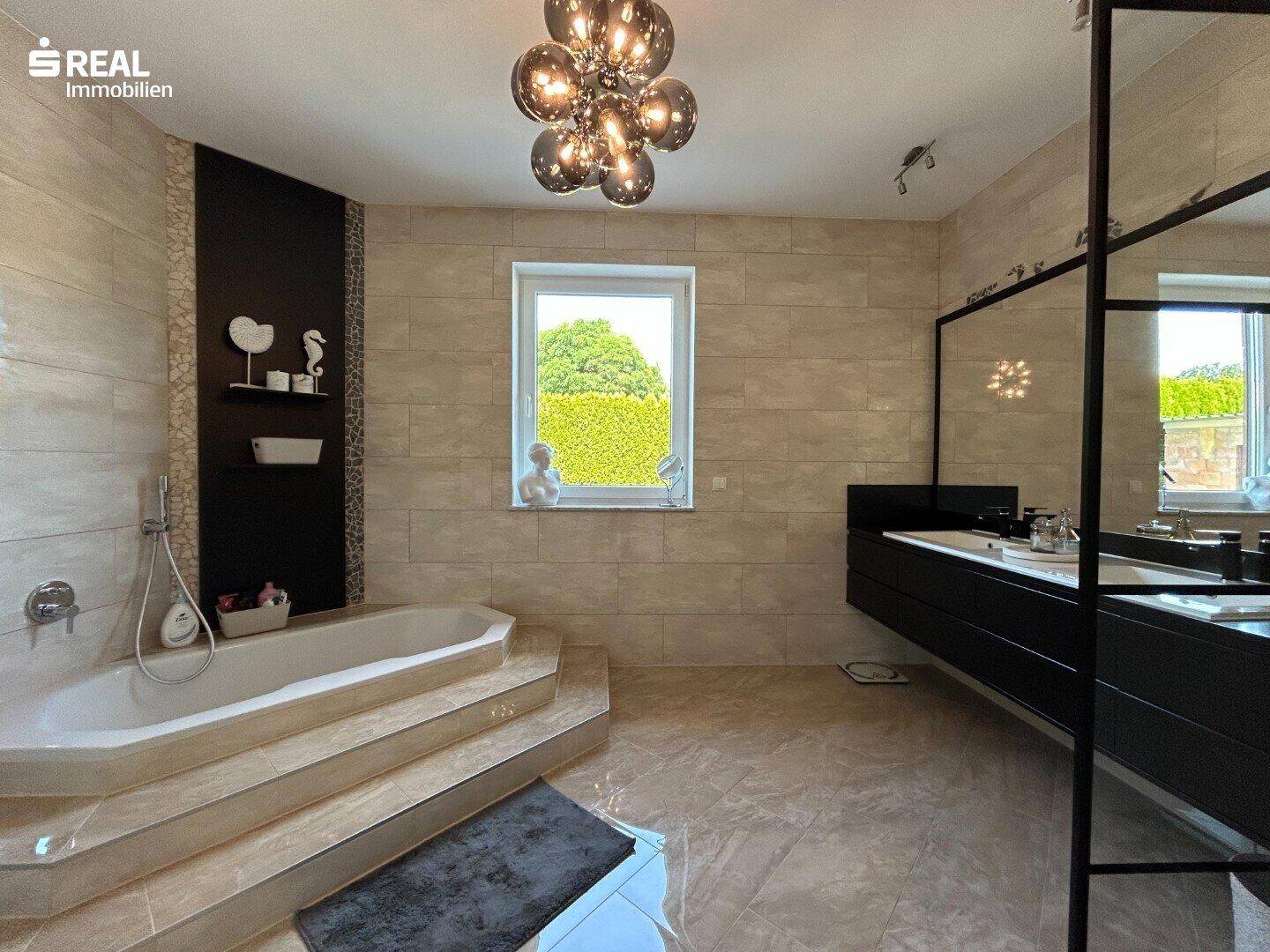 Modernes Badezimmer mit großer Badewanne, Doppelwaschbecken und Fliesenboden.