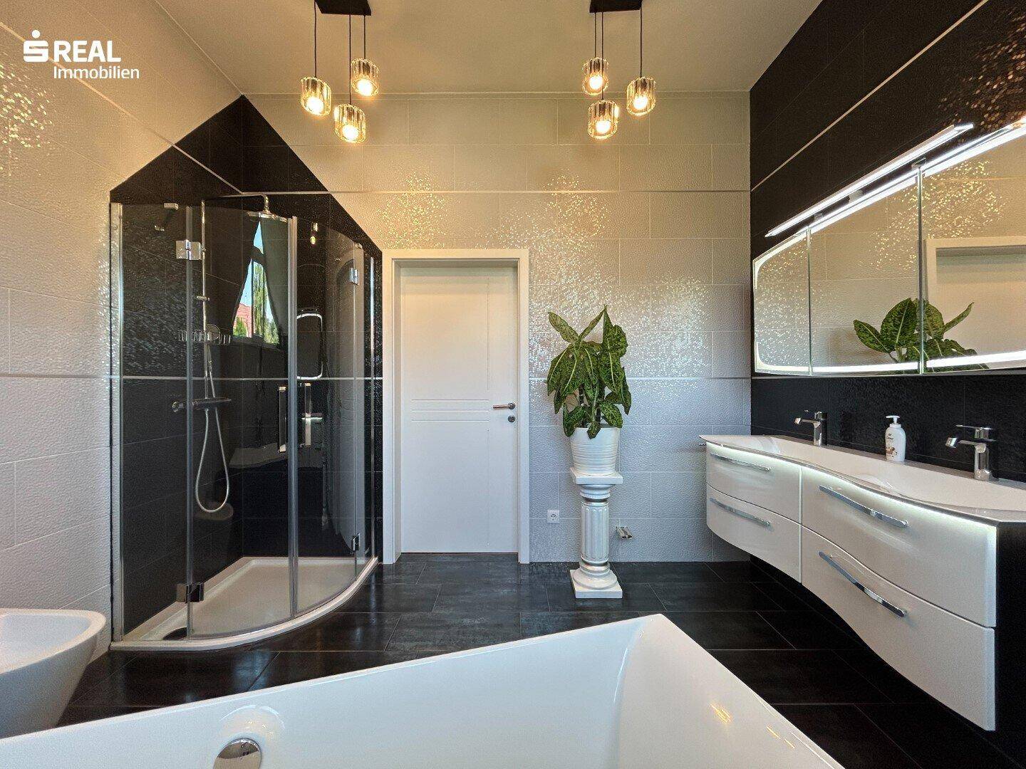 Modernes Badezimmer mit Doppelwaschbecken, Dusche und Badewanne.