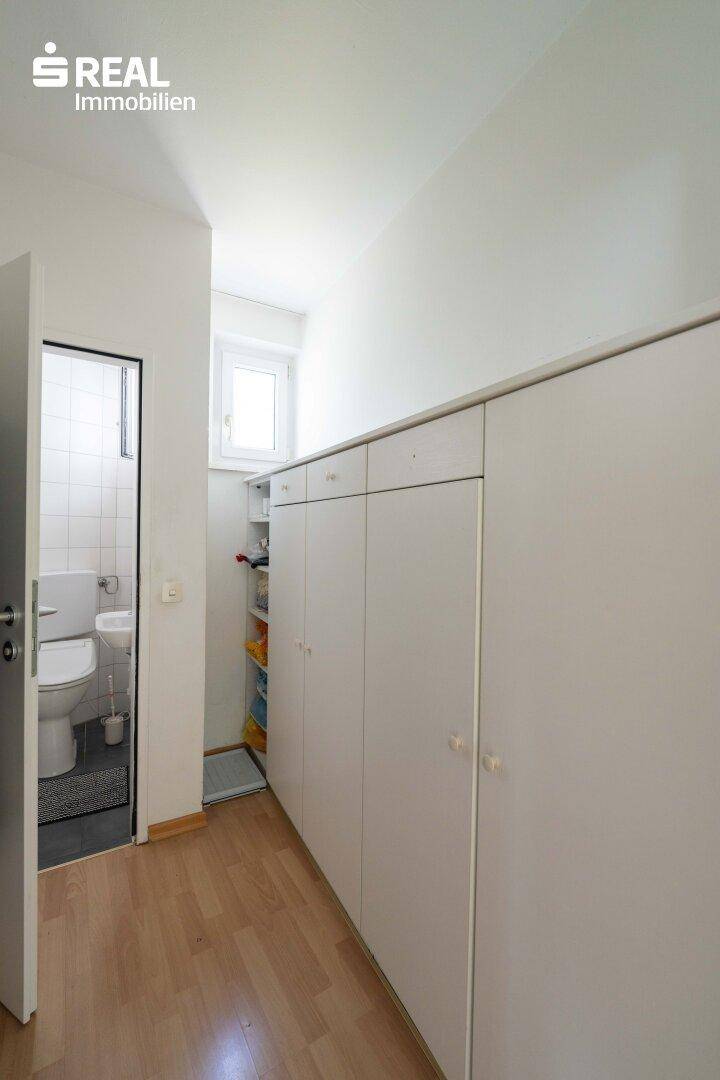 Flur mit praktischen Einbauschränken und Zugang zum Gäste-WC, bietet viel Stauraum.