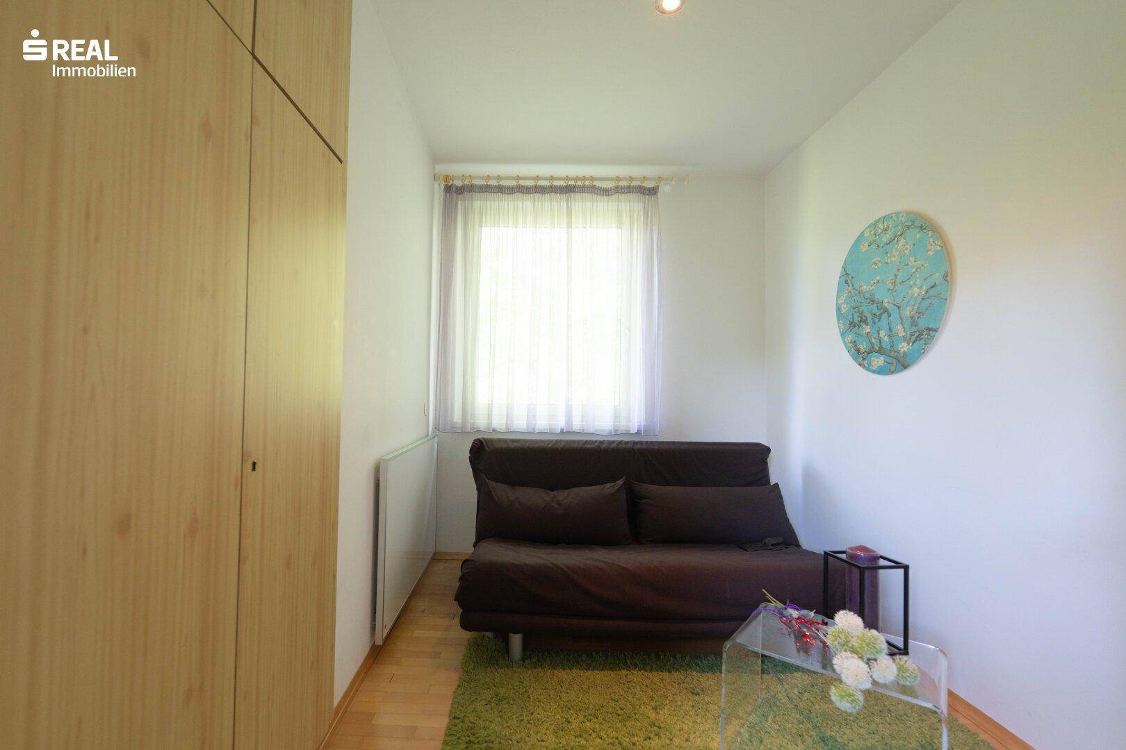 Schlafzimmer mit Schlafsofa und Holzschrank, bietet eine ruhige Atmosphäre.