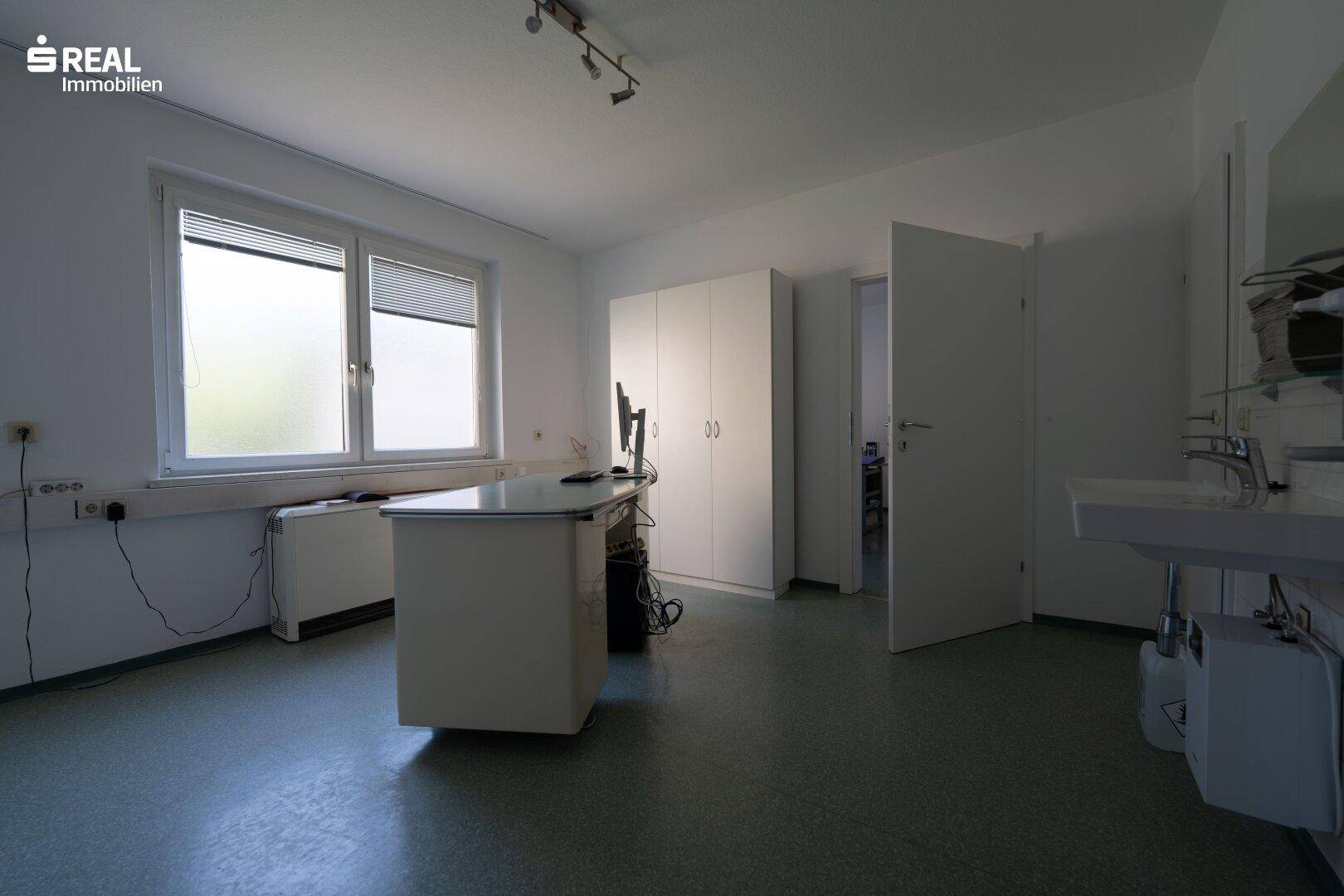 Großes Büro oder Arbeitszimmer mit Fenster, Schränken und Waschbecken, vielseitig nutzbar.