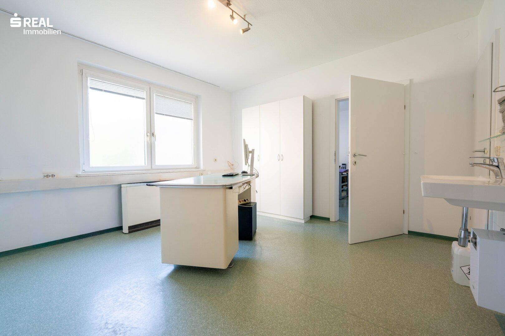 Helles Büro mit Schreibtisch, Schränken und einem Waschbecken, ideal für eine Praxis oder Kanzlei.