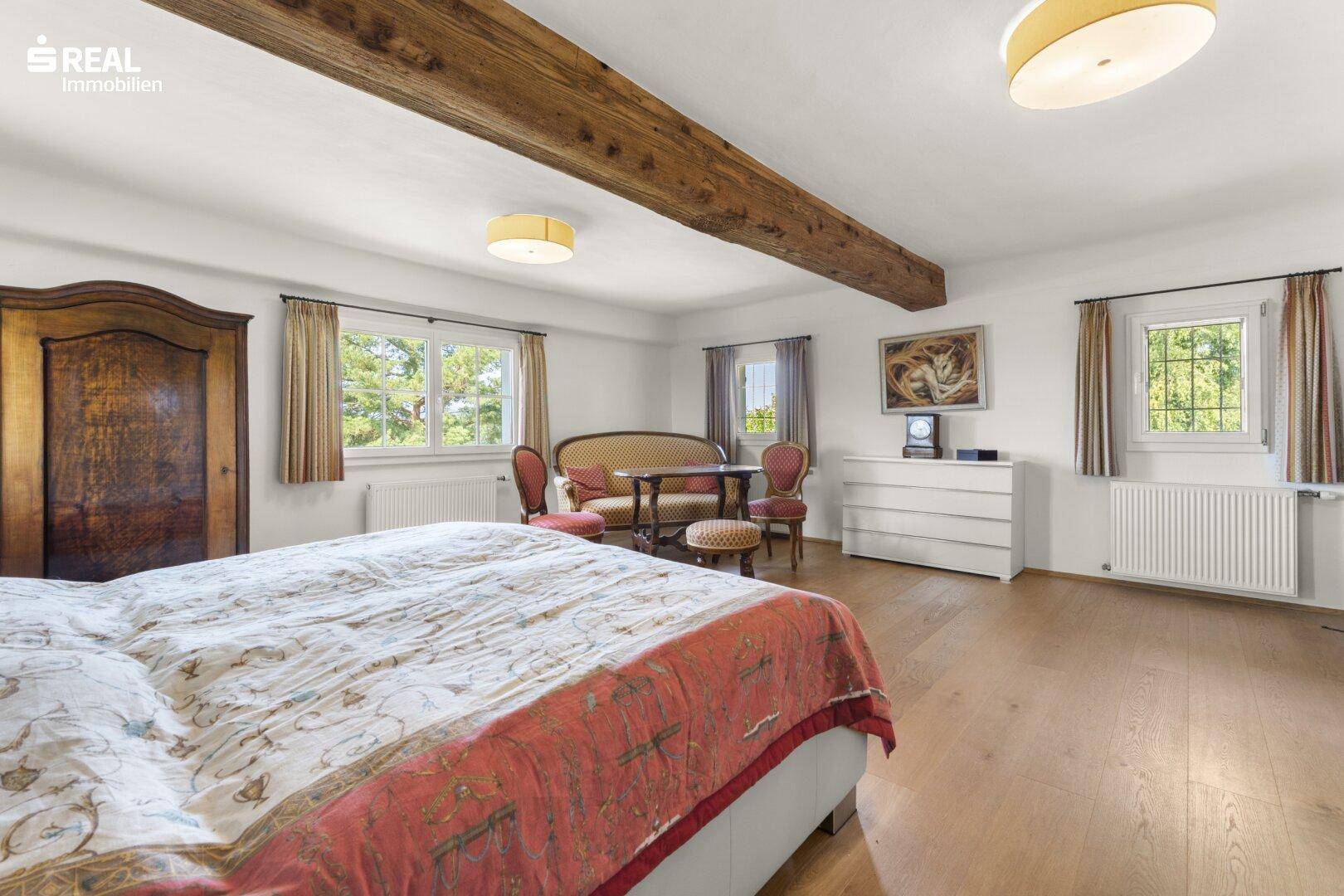Geräumiges Schlafzimmer mit Holzbalken, Holzboden und traditionellen Möbeln.