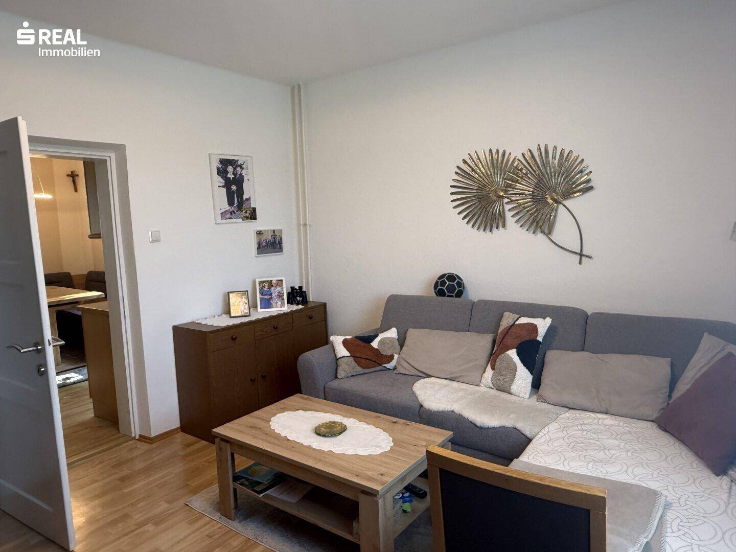Gemütliches Wohnzimmer mit Sofa, Couchtisch und dekorativen Elementen.