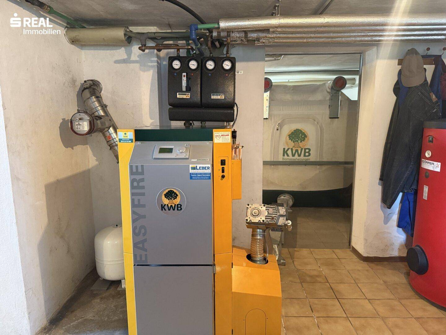 Heizungsraum im Keller mit moderner Pelletheizung und Warmwasserspeicher.