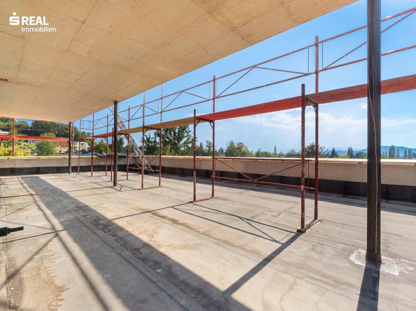 Weitläufige, unfertige Dachterrasse mit Gerüst und weitem Blick in die Landschaft.