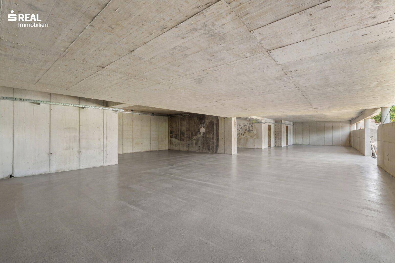 Großer, unfertiger Kellerraum mit Betonwänden und -boden, ideal als Lagerfläche.