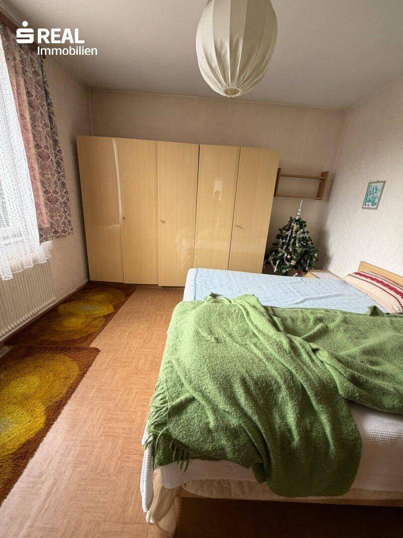 Schlafzimmer mit Doppelbett, großem Kleiderschrank und einem kleinen Weihnachtsbaum.