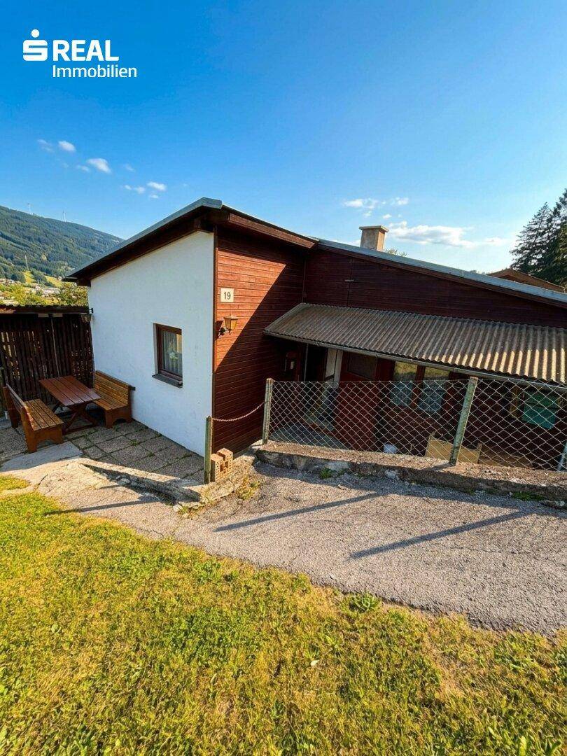 Kleines Nebengebäude mit Sitzgelegenheit im Freien und Blick auf die umliegende Landschaft.