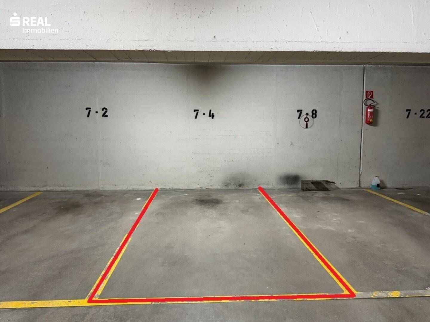 Einzelner Parkplatz in einer Tiefgarage mit klaren Markierungen auf dem Betonboden.