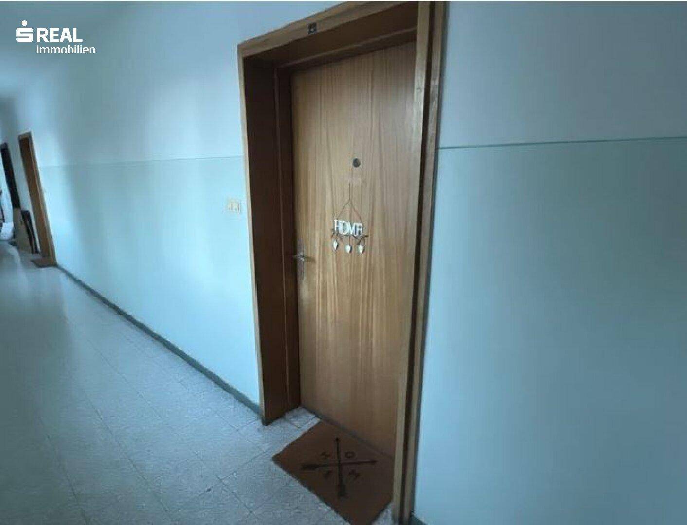 Heller Flur mit mehreren Wohnungstüren und schlichtem Design im Mehrfamilienhaus.