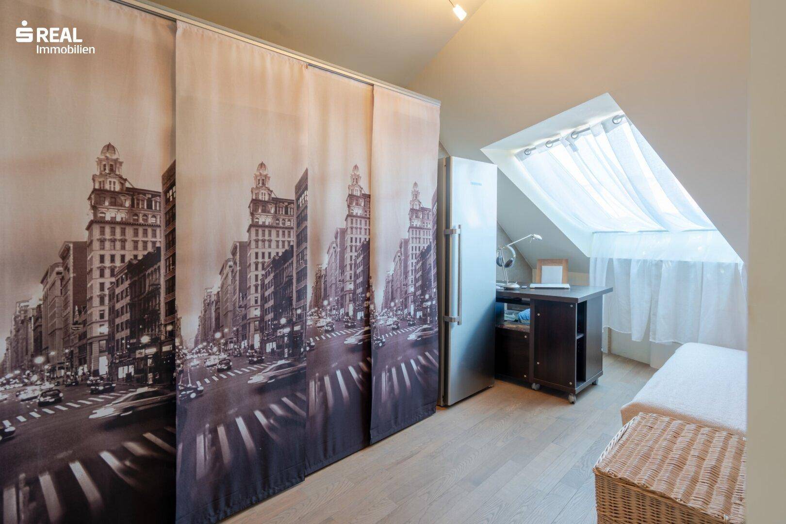 Dachzimmer mit Schreibtisch, Dachfenster und dekorativen Schiebetüren.
