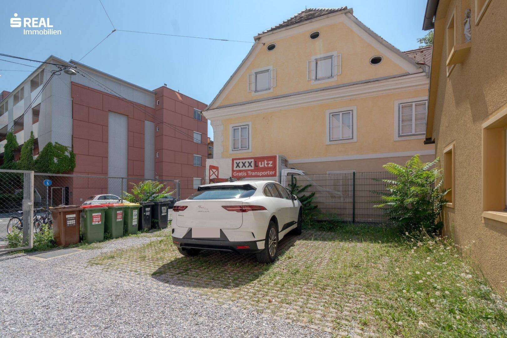 Außenbereich mit Parkplätzen und einem Gebäude im Hintergrund.