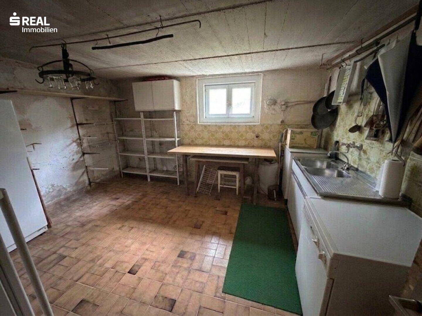 Kellerraum als Werkstatt oder Abstellraum mit Spüle und Regalen.