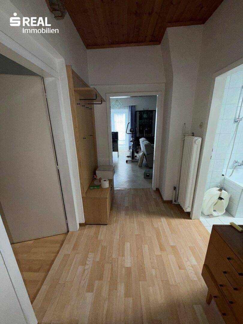 Heller Flur mit Laminatboden und Zugang zu weiteren Räumen, inklusive Badezimmer.
