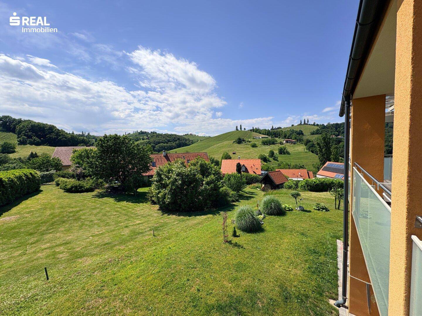 Panoramablick auf die sanften grünen Hügel und die umliegende ländliche Bebauung.