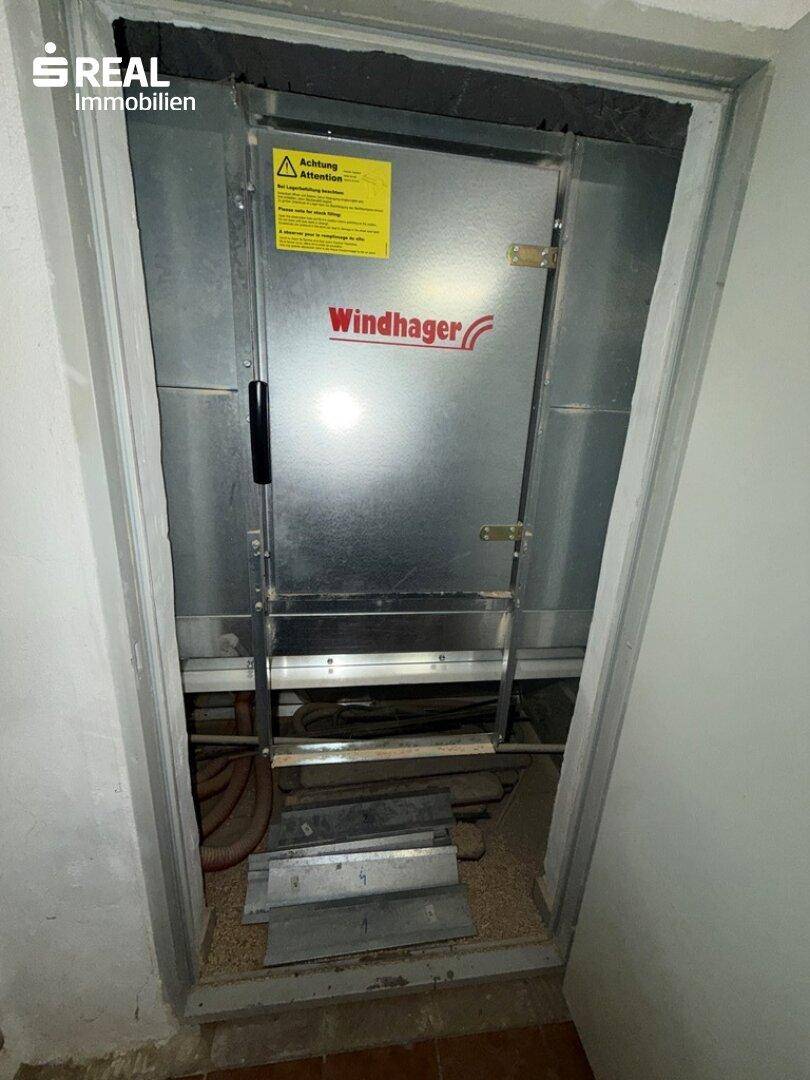 Detailansicht des Windhager Heizsystems in einem Kellerraum mit Metallverkleidung.