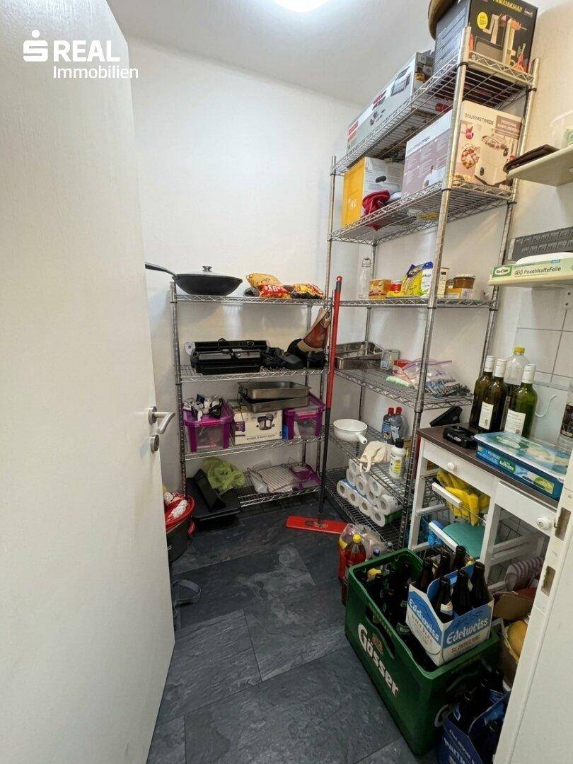 Praktische Speisekammer mit Metallregalen für Vorräte und Haushaltsartikel.