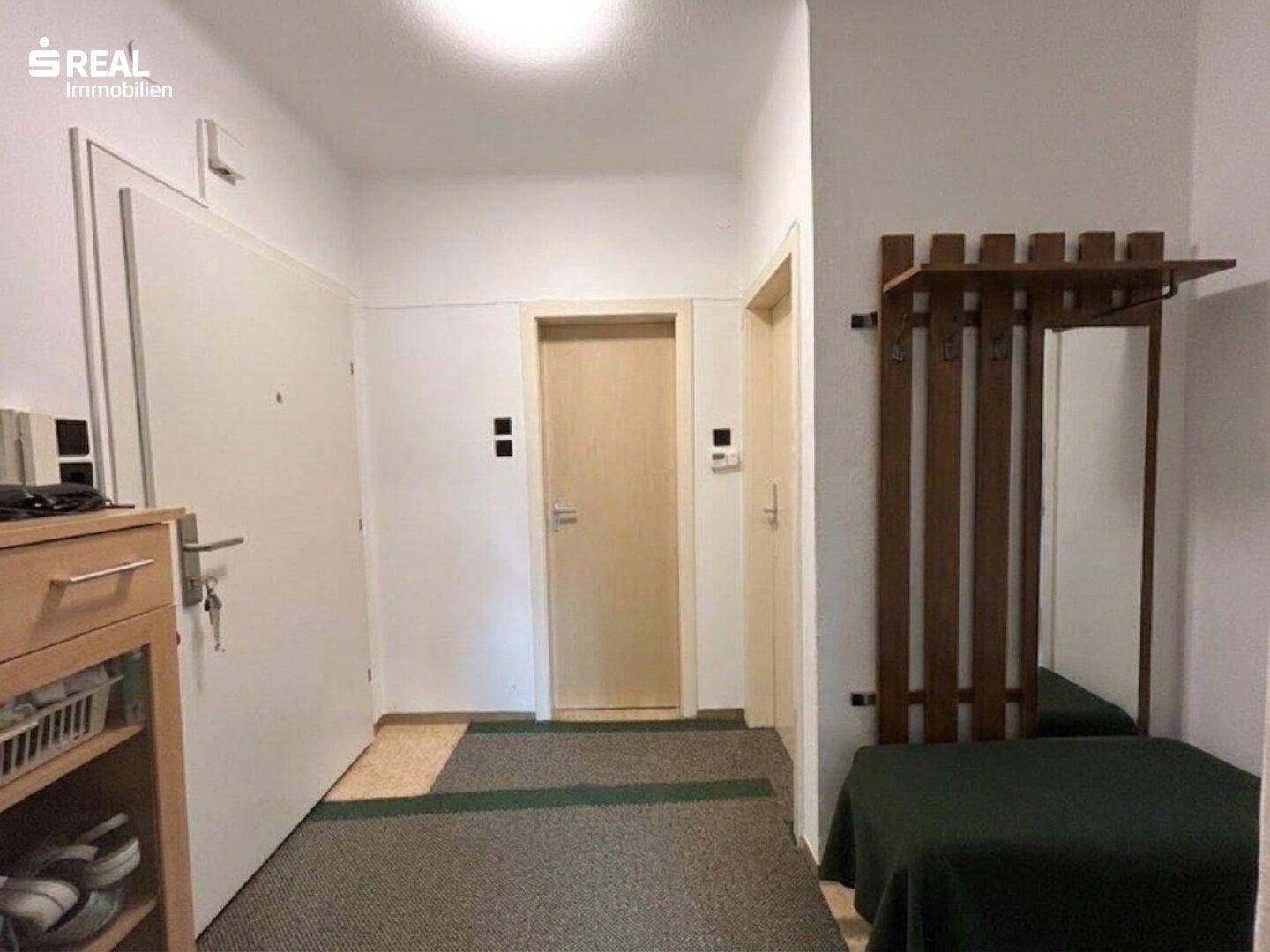 Heller Eingangsbereich mit Garderobe und Zugang zu den weiteren Räumen.