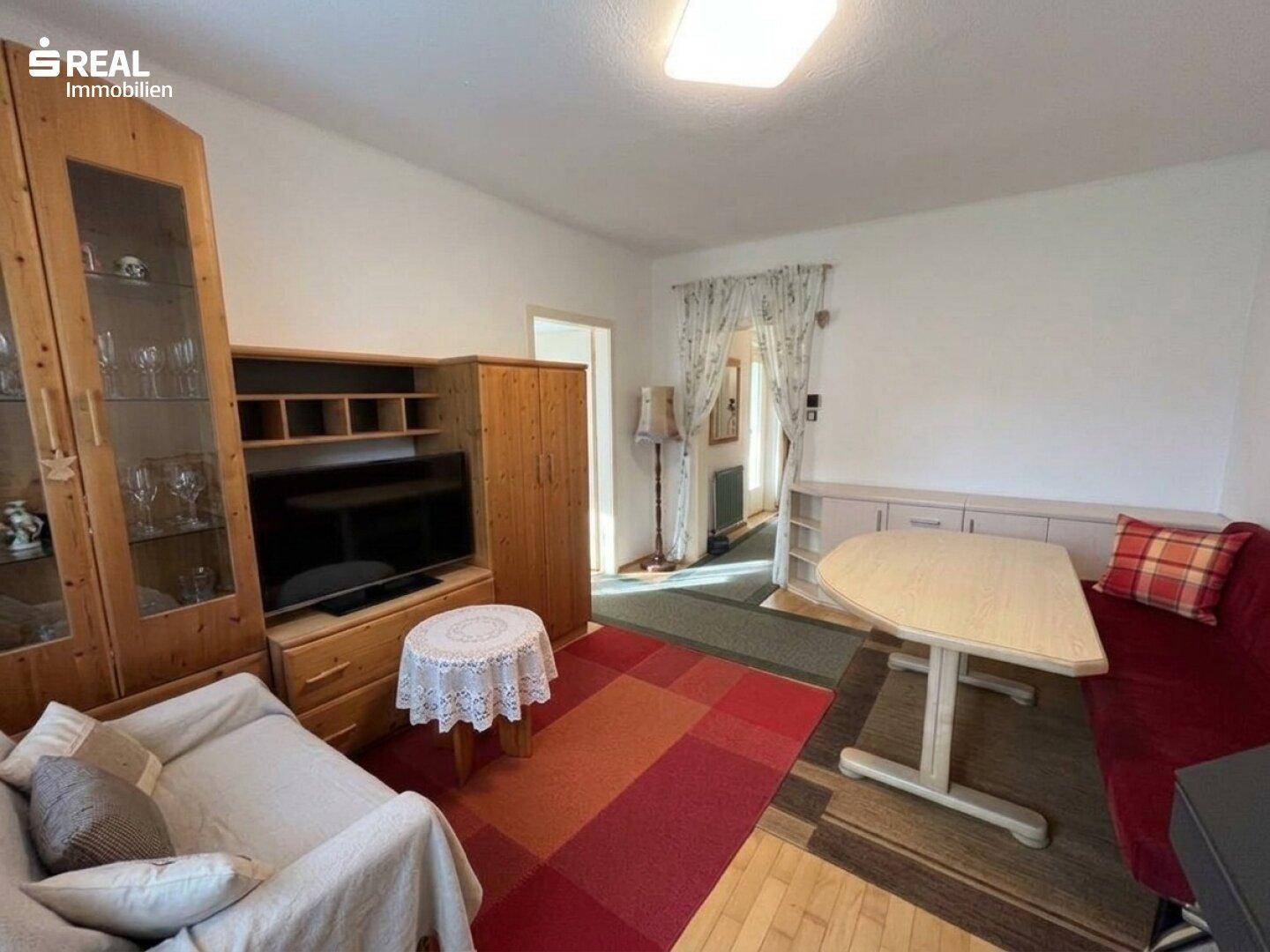 Geräumiges Wohnzimmer mit Sitzgelegenheiten und Unterhaltungsmöbeln.