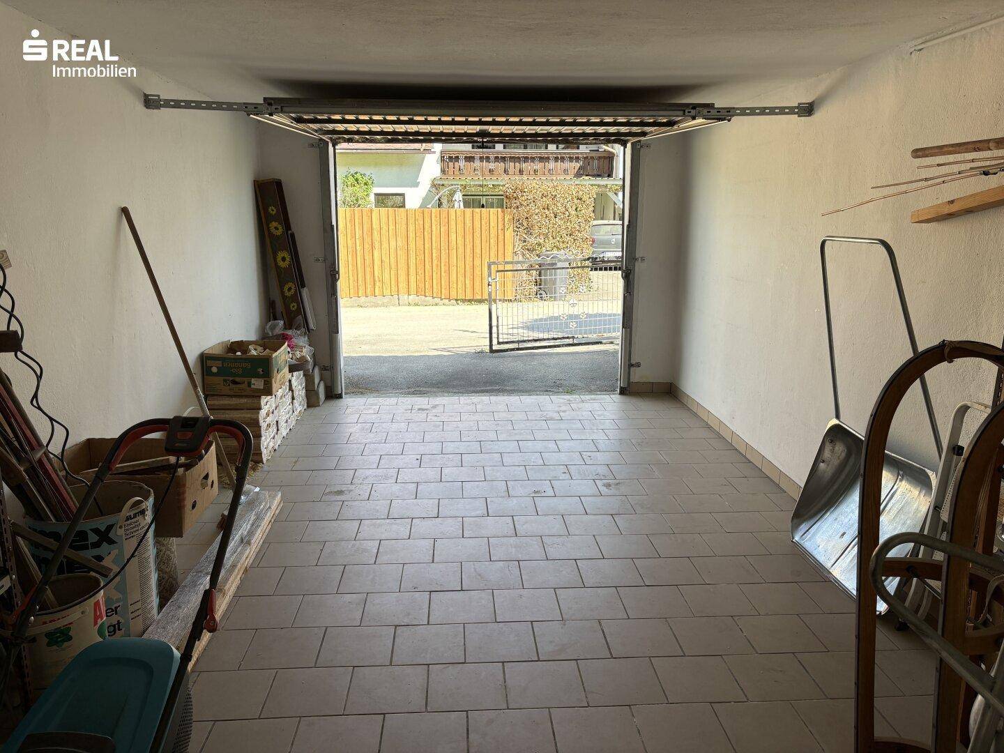 Geräumige Garage mit Fliesenboden und direktem Zugang zum Außenbereich.
