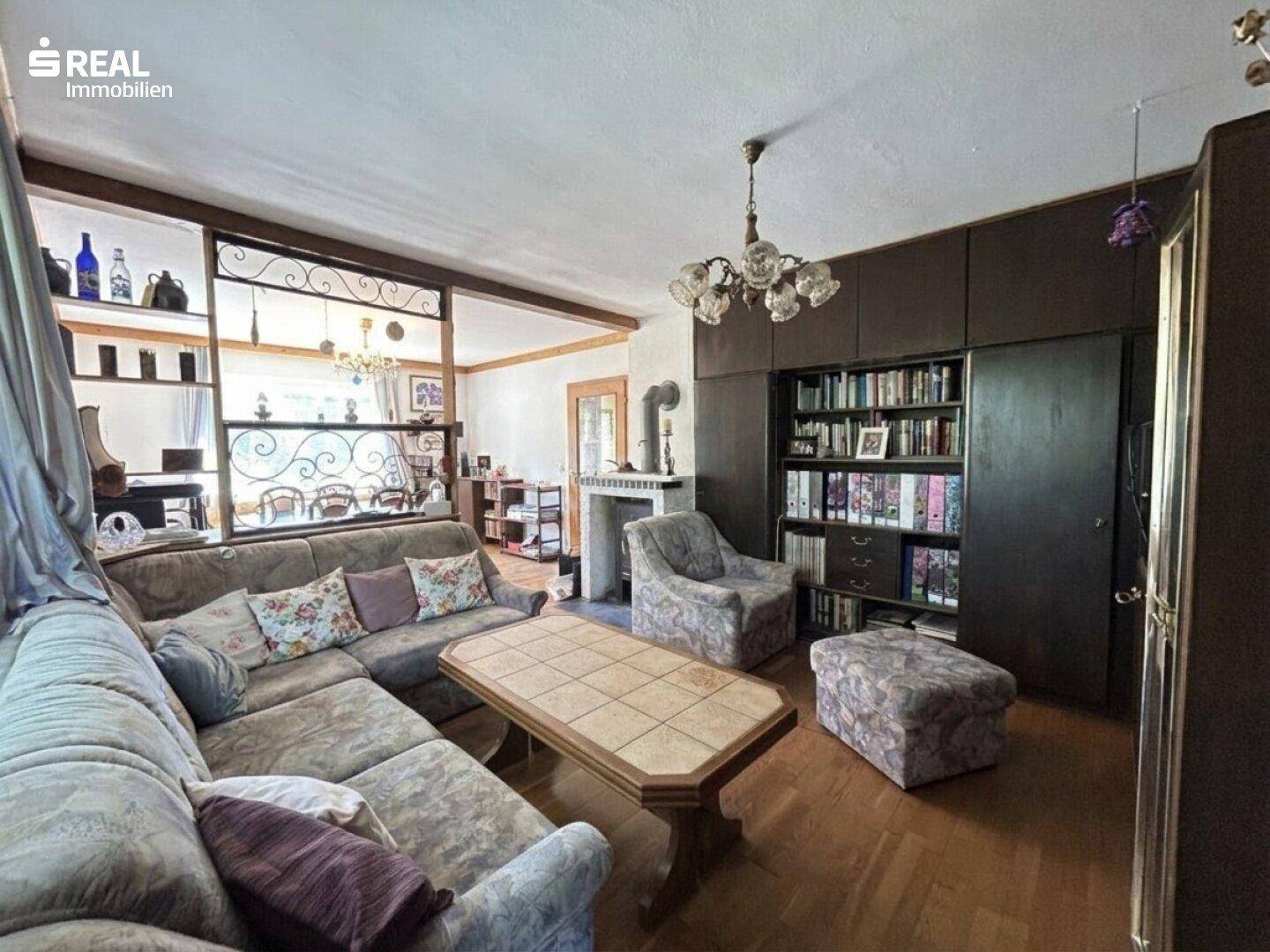 Gemütliches Wohnzimmer mit großem Sofa, Einbauschränken und einem traditionellen Kamin.