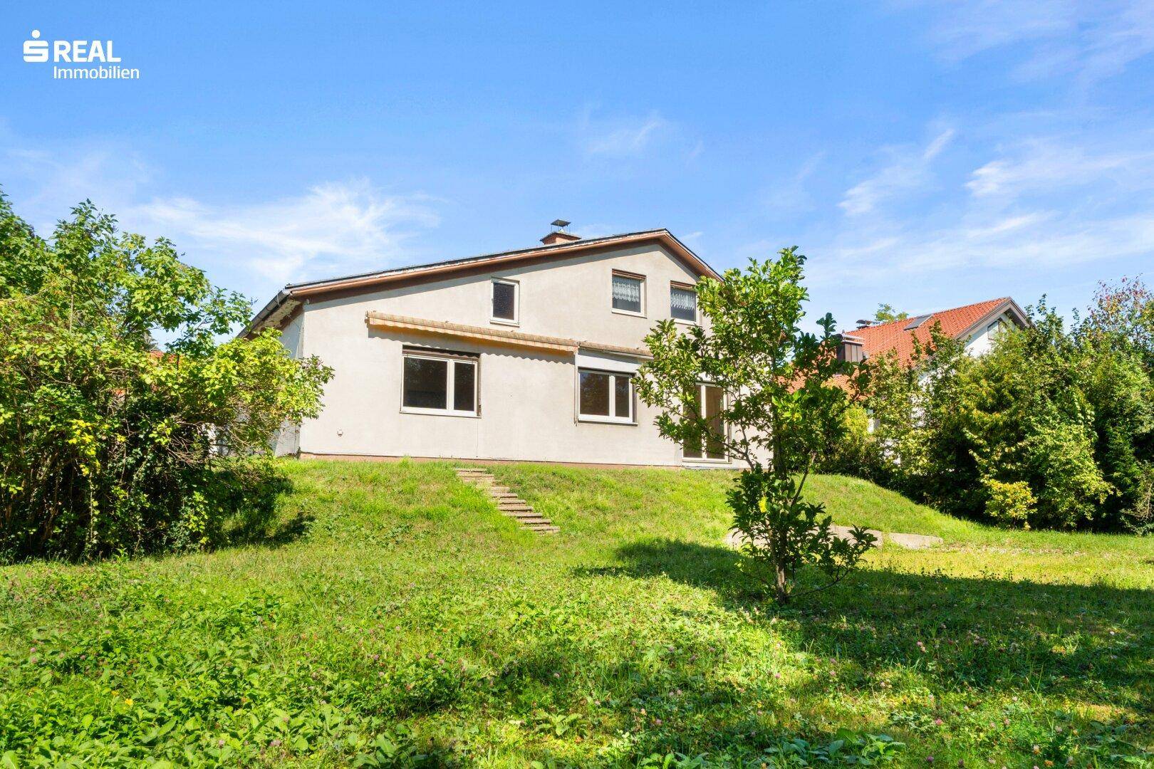Rückseite des Hauses mit Zugang zum Garten über eine kleine Treppe.