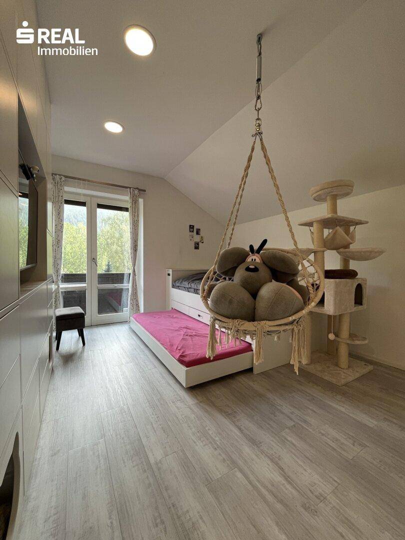 Gemütliches Schlafzimmer mit Bett, Hängesessel und Zugang zu einem Balkon oder Garten.