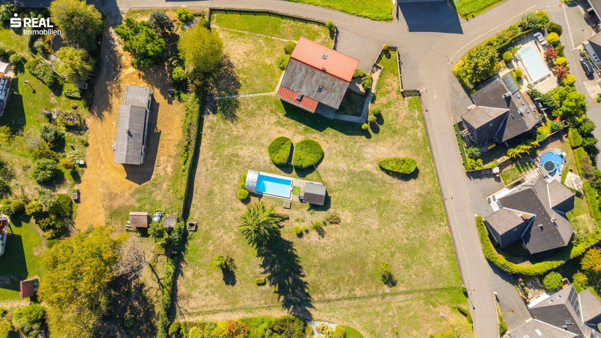 Senkrechte Luftaufnahme des Grundstücks mit Haus, Swimmingpool und umliegenden Gärten.