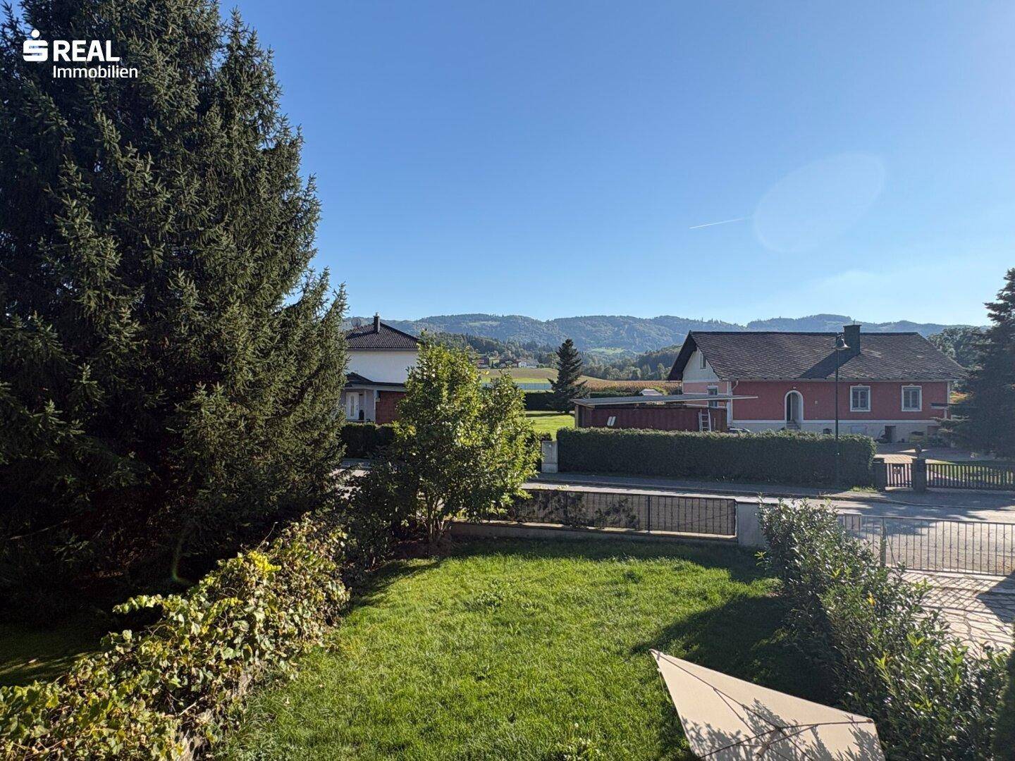Weitläufiger Blick über grüne Hügel und die umliegende Landschaft an einem klaren Tag.
