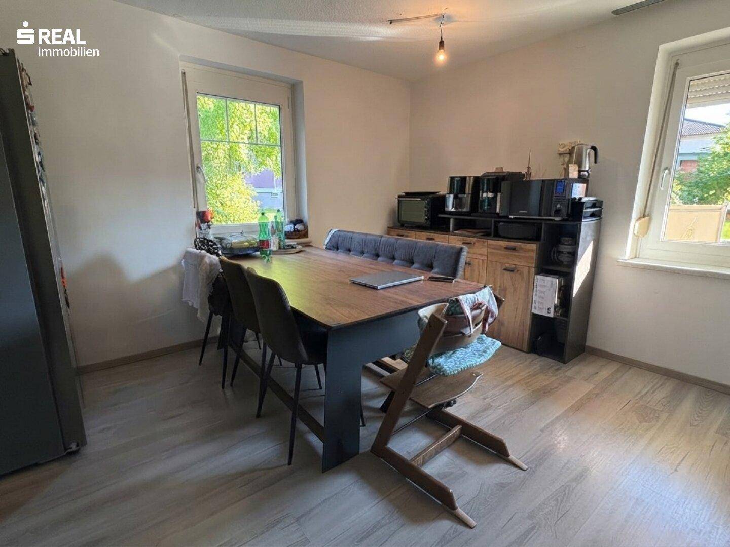Heller Essbereich mit Holztisch und bequemen Stühlen, ideal für Familienmahlzeiten.