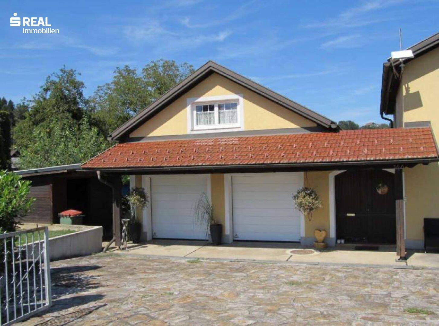 Doppelgarage mit Satteldach und zusätzlichem Carport, bietet ausreichend Parkmöglichkeiten.