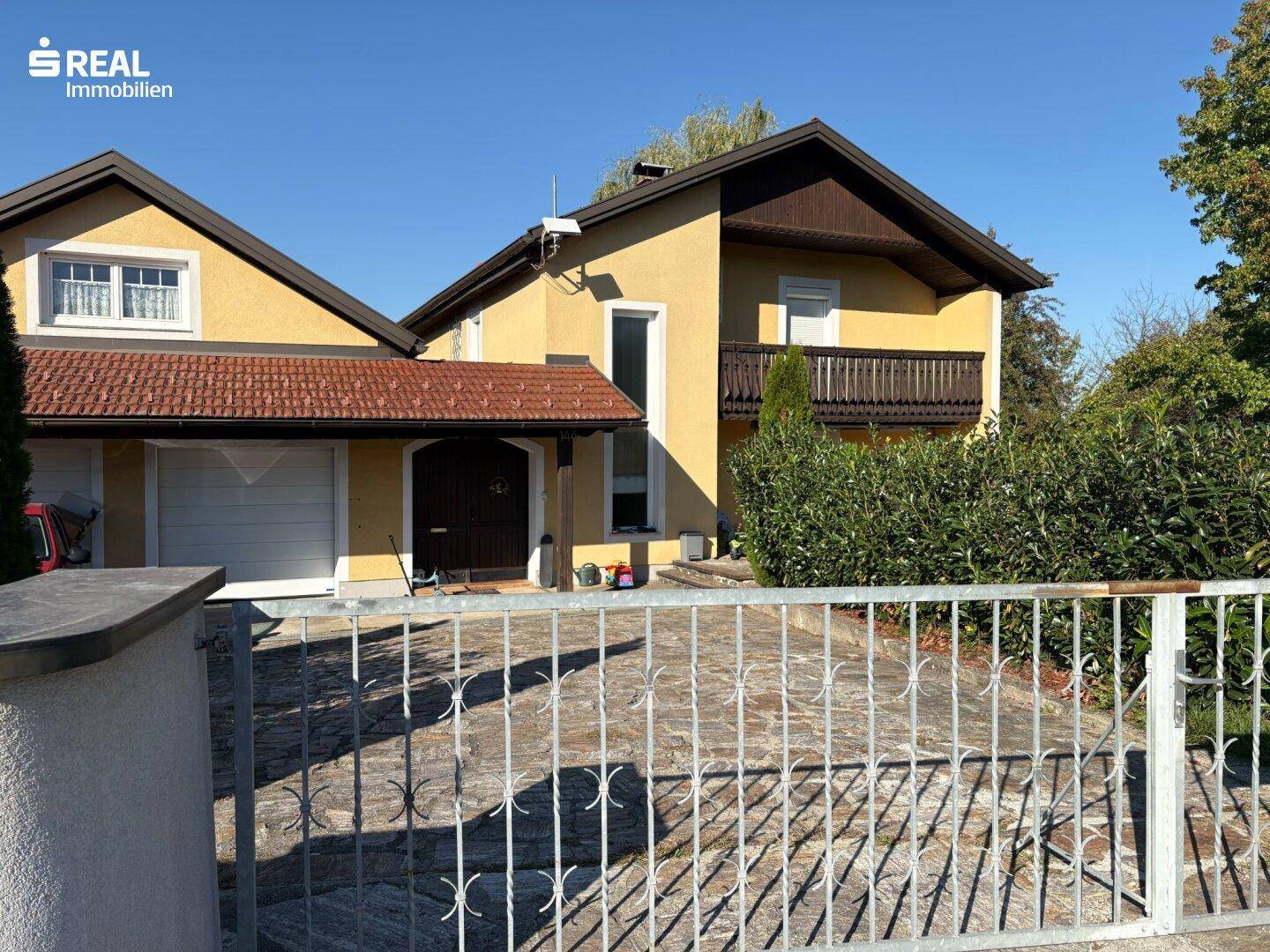 Ansicht des Hauses von der Straße mit Vorgarten und Zufahrt zur Garage.