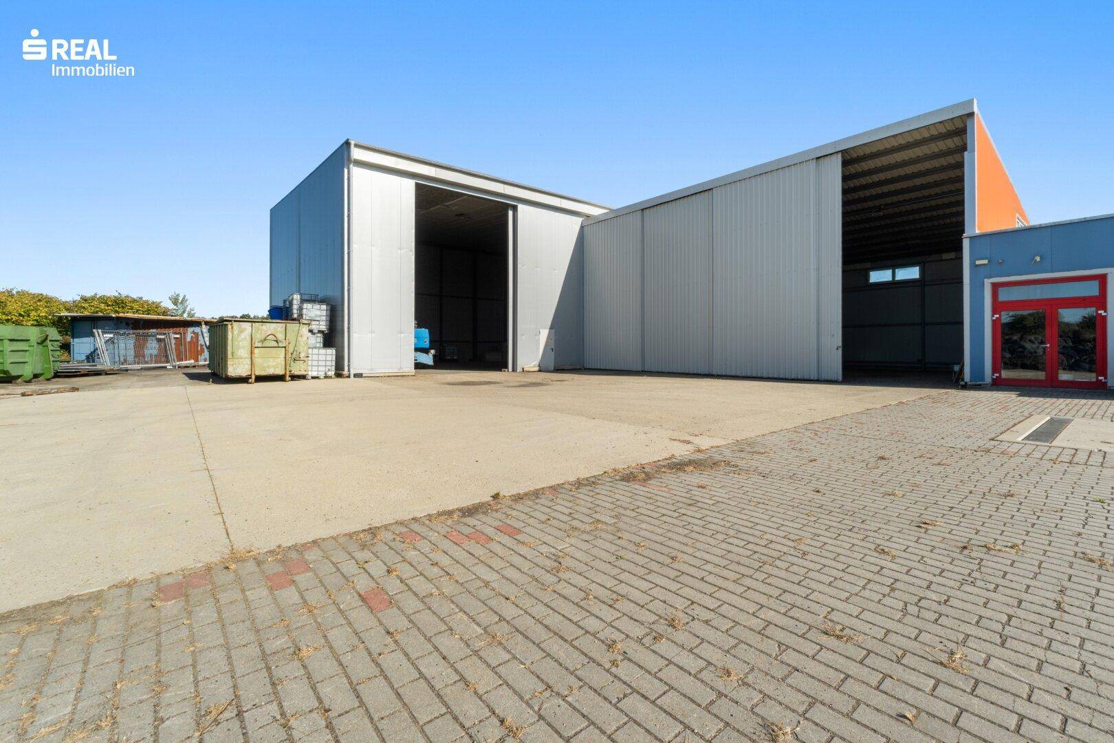 Weitläufiges Außengelände mit Zufahrt zu den großen Lagerhallen und einem kleineren Gebäude.
