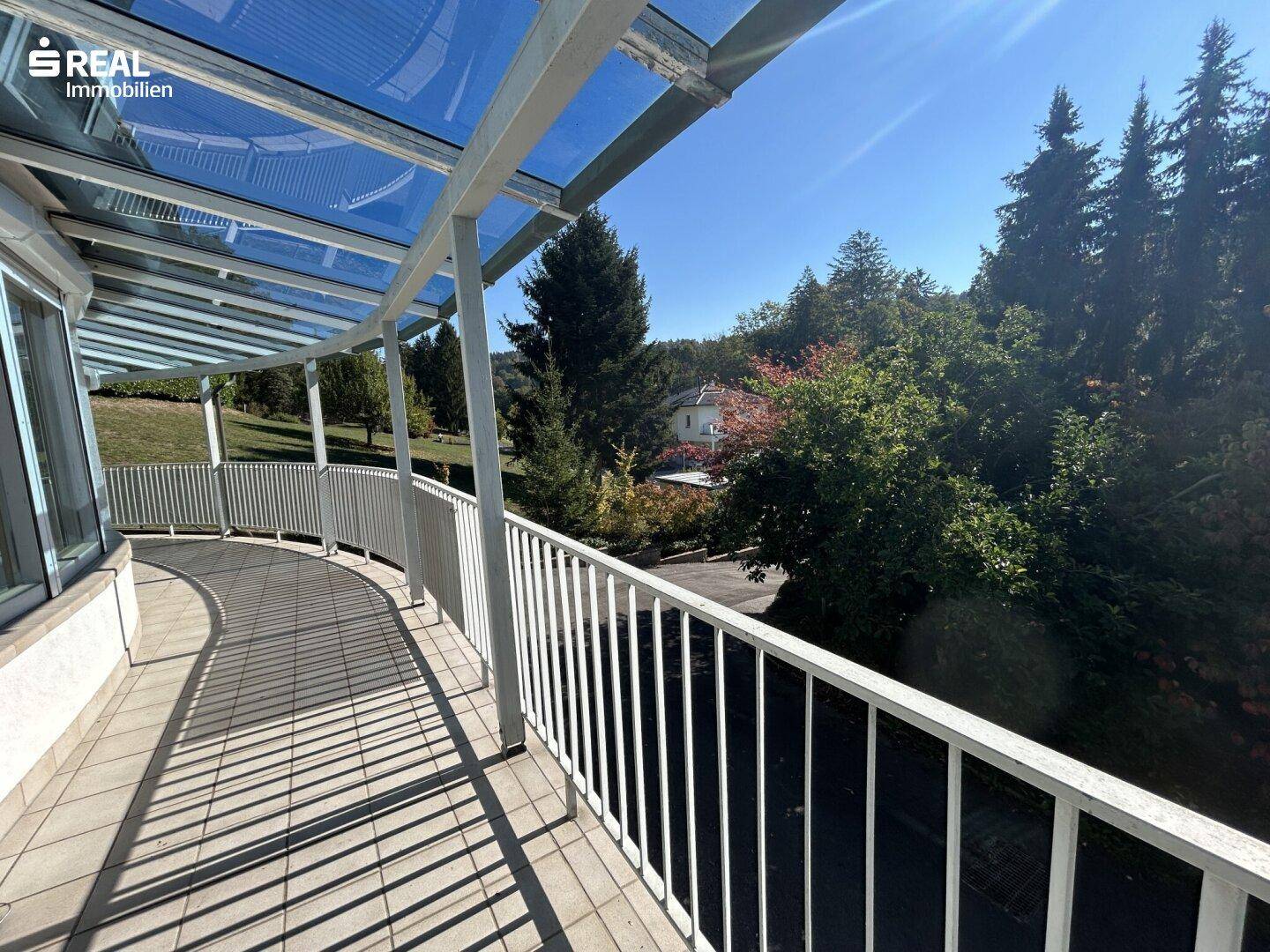 Runder, überdachter Balkon mit Fliesenboden und weitem Blick in die Landschaft.