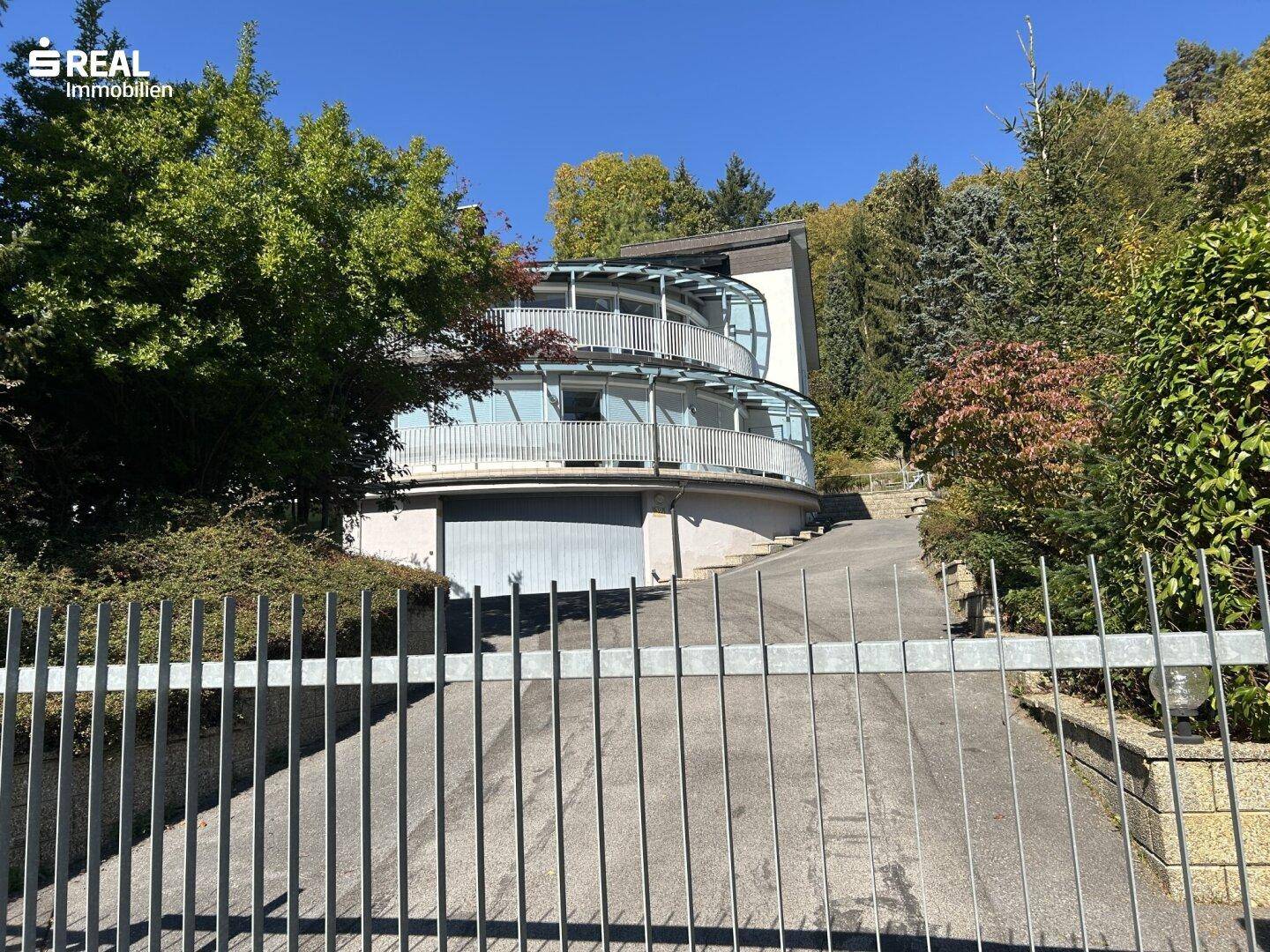 Architektonisch interessantes Haus mit geschwungenen Balkonen und integrierter Garageneinfahrt.