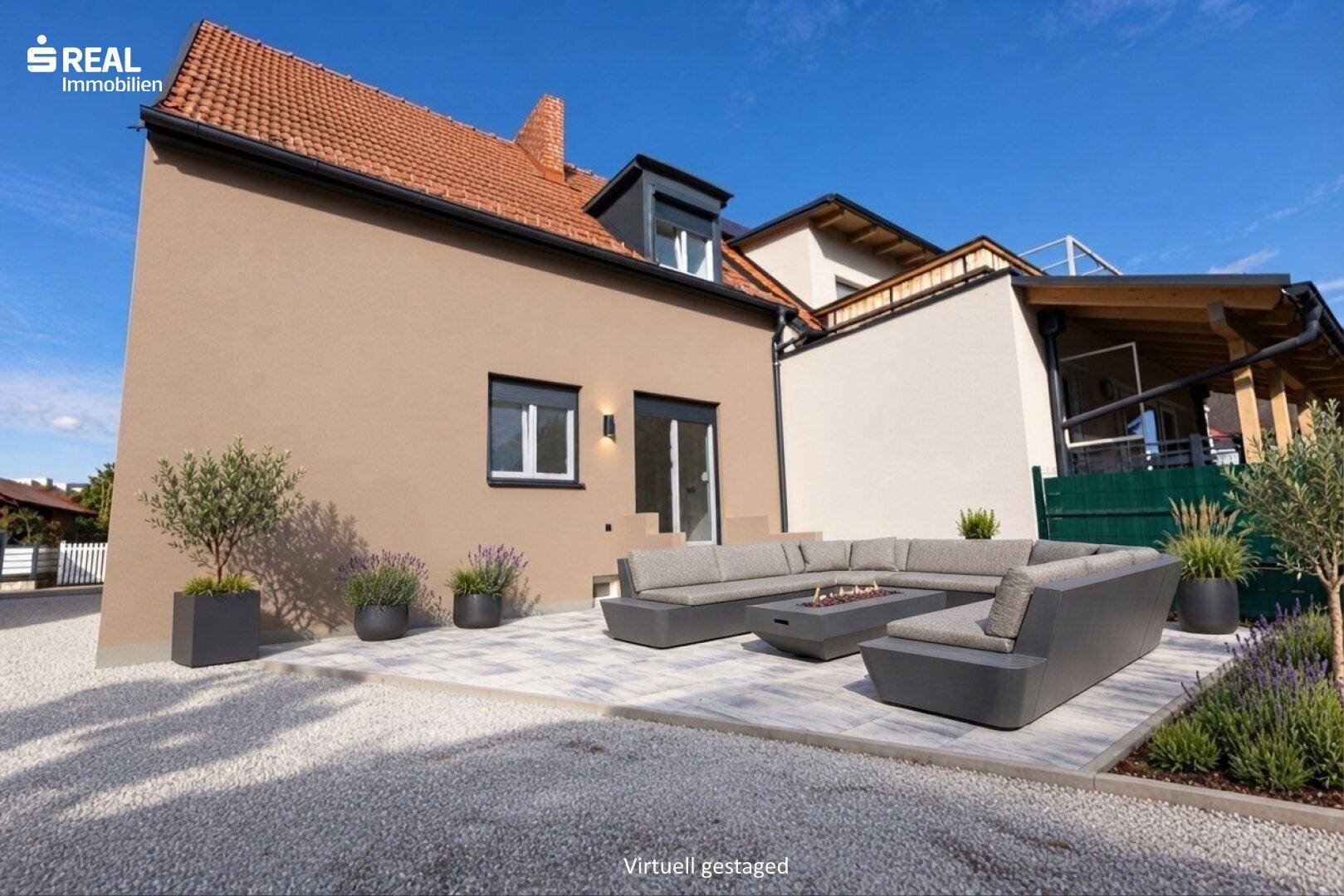 Moderne Terrasse mit bequemen Outdoor-Sitzmöbeln, Feuerstelle und Kiesgarten vor dem Haus.
