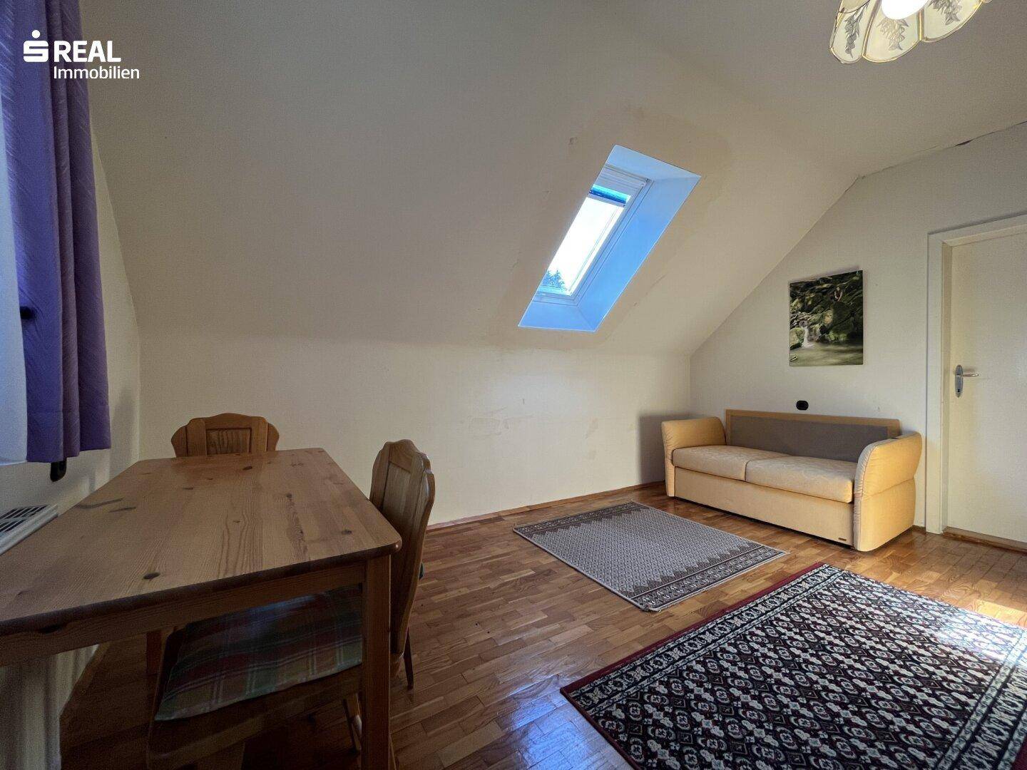 Heller Wohn-Essbereich im Dachgeschoss mit Holzboden, Dachfenster und Schrägen, geräumig.