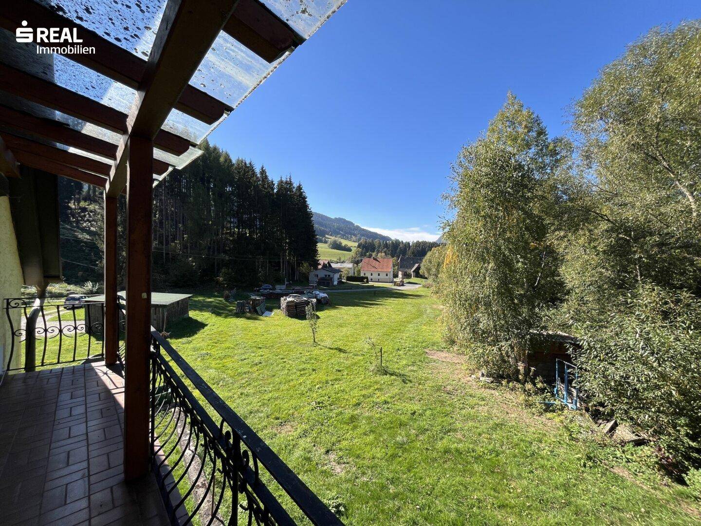 Balkon mit weitem Blick über grüne Wiesen und die umliegende hügelige Landschaft.