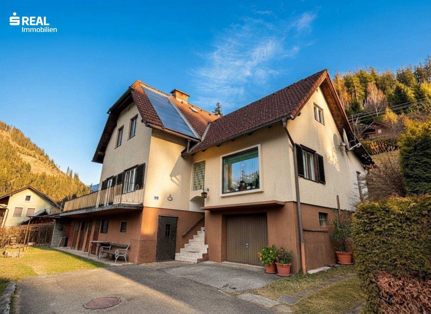 Gut erhaltenes Einfamilienhaus mit Satteldach, Photovoltaikanlage und integrierter Garage in bergiger Umgebung.