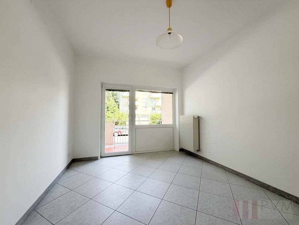 Helles Zimmer mit Fliesenboden und direktem Zugang zu einem Balkon, vielseitig nutzbar.