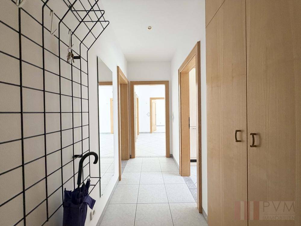 Funktionaler Flur mit Fliesenboden, integrierten Schränken und Garderobe, verbindet die Wohnbereiche.