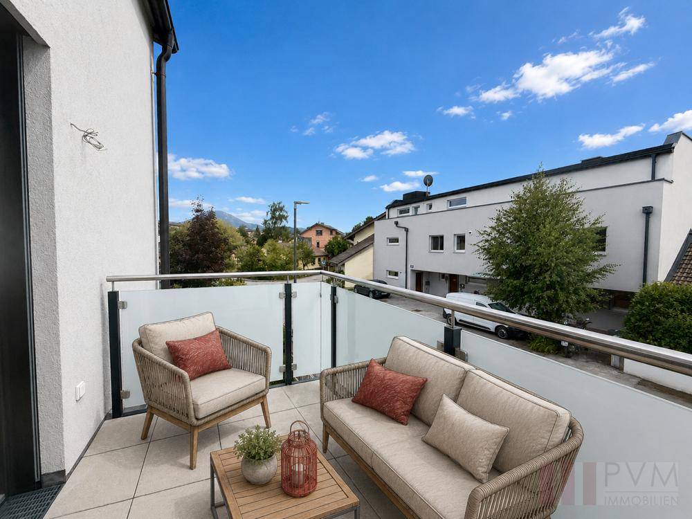 Möblierter Balkon mit bequemen Sitzgelegenheiten und Blick auf die Umgebung.
